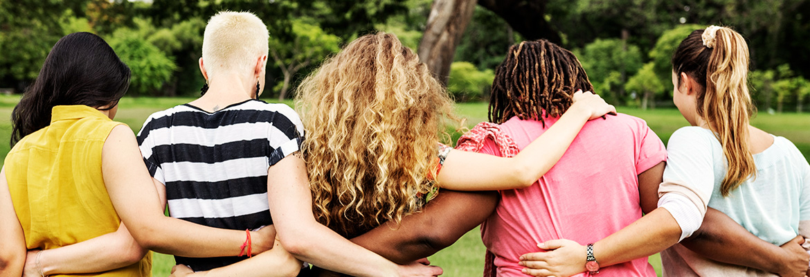 group of women of all types of backgrounds walking arm in arm outside