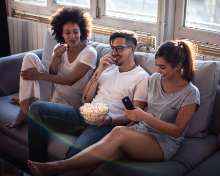 group of people sitting on the couch watching television
