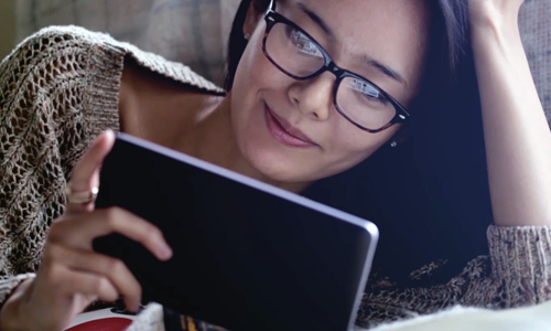 Woman laying down while streaming video from a tablet