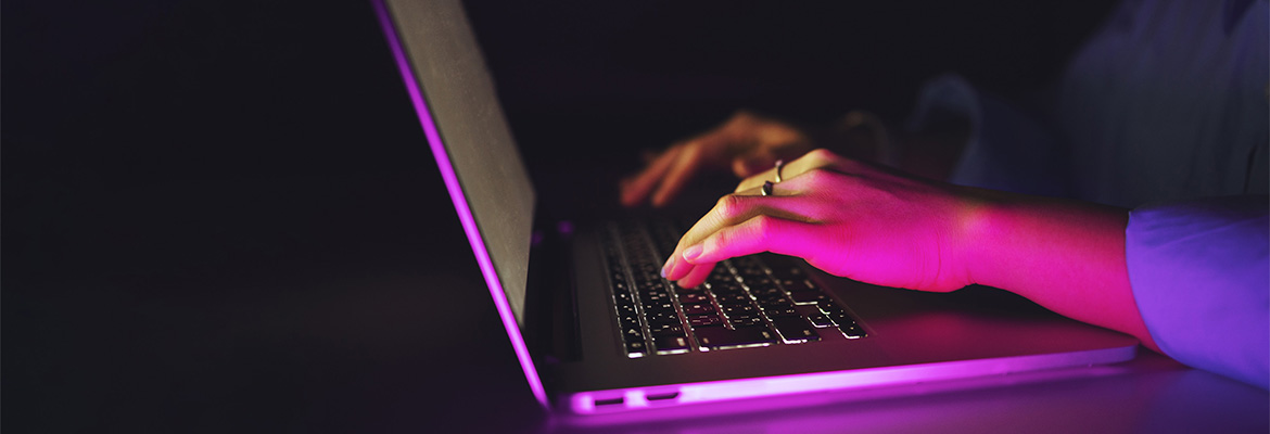 hands typing on a laptop keyboard