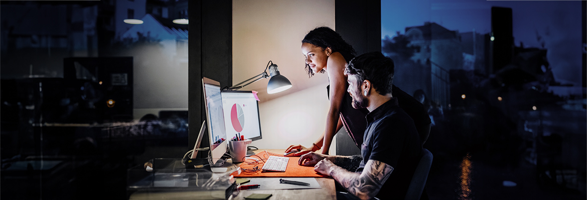 two people working run an office looking at a computer screen