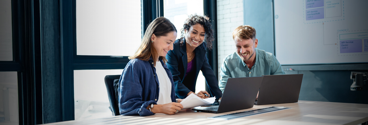 Group of three people working together at a conference table