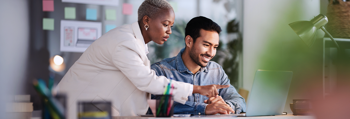 Business professionals working together on a laptop in an office