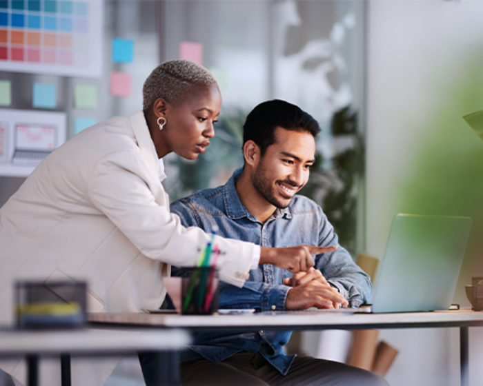 Business professionals working together on a laptop in an office