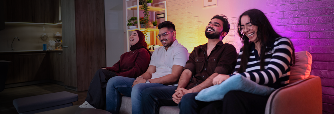 Diverse group of friends on the couch smiling laughing and watching TV