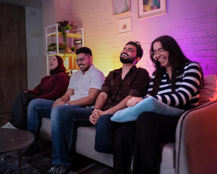 Diverse group of friends on the couch smiling laughing and watching TV