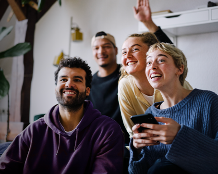 Diverse group of friends smiling laughing and watching TV
