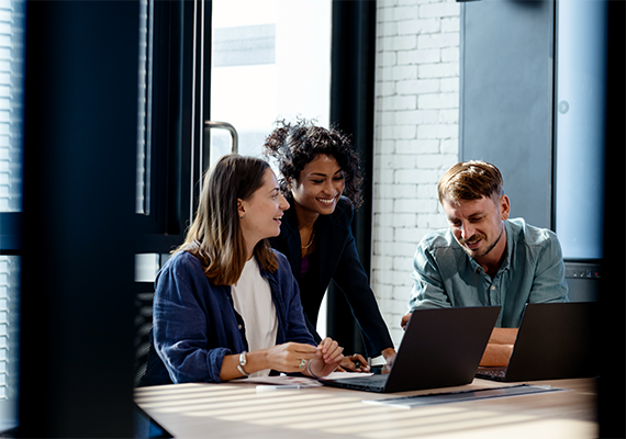 Three people working at a conference table