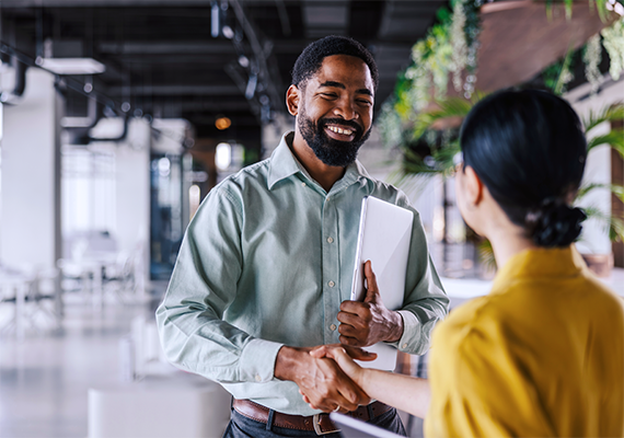 man and woman in a work environment shaking hands