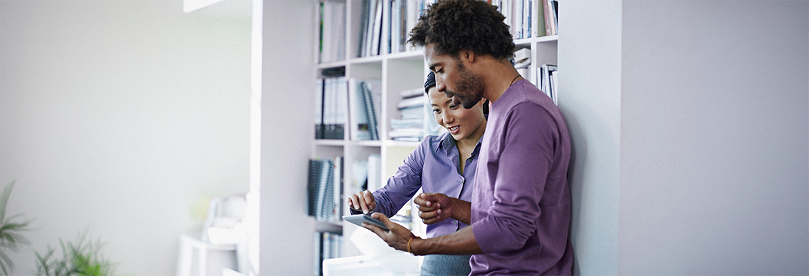 two people in a business setting looking at a tablet